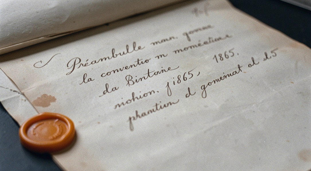 Gros plan sur le préambule manuscrit de la convention monétaire de 1865, écriture à la plume, sceau de cire ocre intact en marge, ombre douce de papier ancien