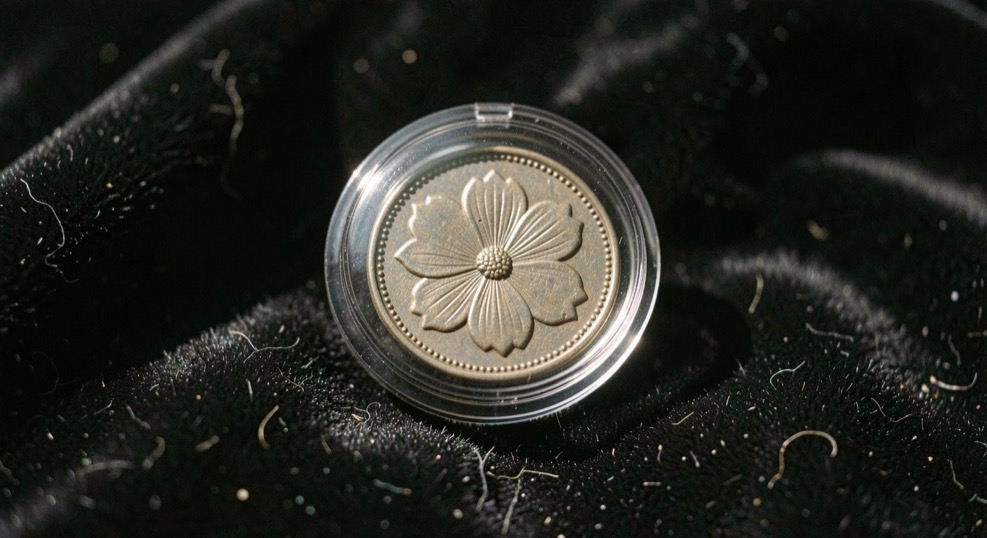 Monnaie fleur de coin dans sa capsule étanche posée sur velours noir, brillant original intact, aretes des reliefs tranchantes sous l'éclairage rasant